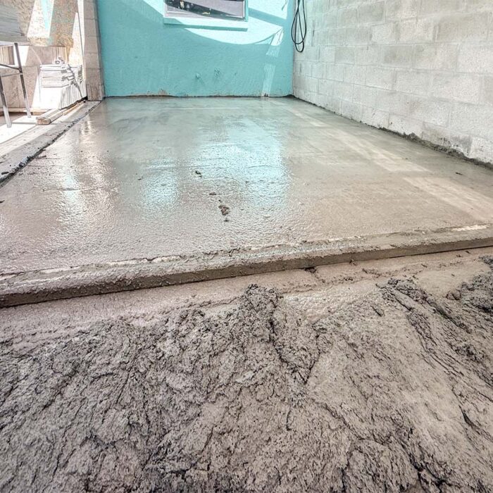 Creating outdoor kitchen requires an easy to clean floor. In this case, the cement slab, while in excellent condition, was flat and lacked sufficient slope to adequately direct standing water to the drain. The answer to this problem is to install an overlay to create an adequate slope.