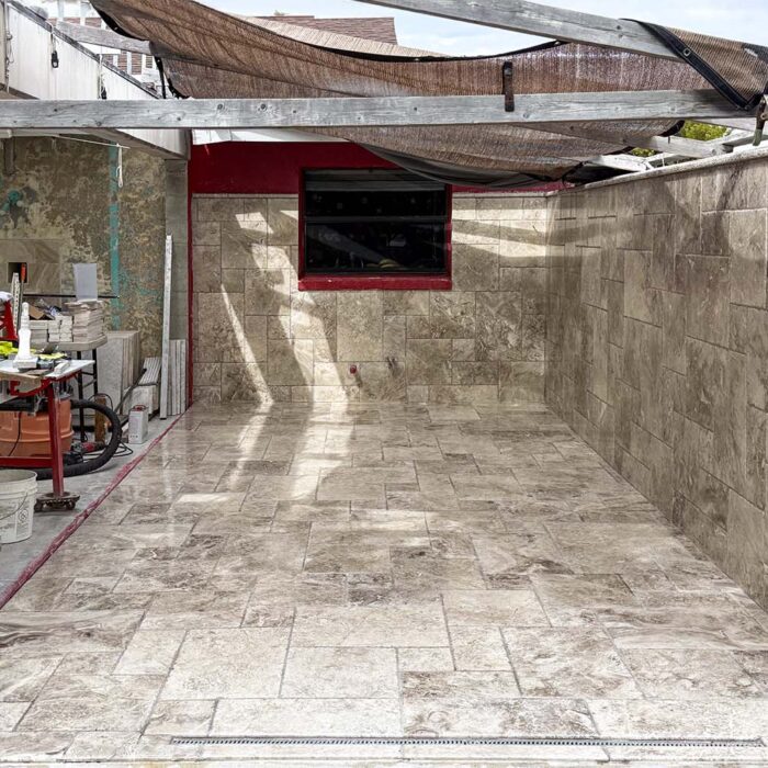 With the new properly installed overlay is finished stone tiles. Excellent drainage and utility. That what we call a concrete solution by design.