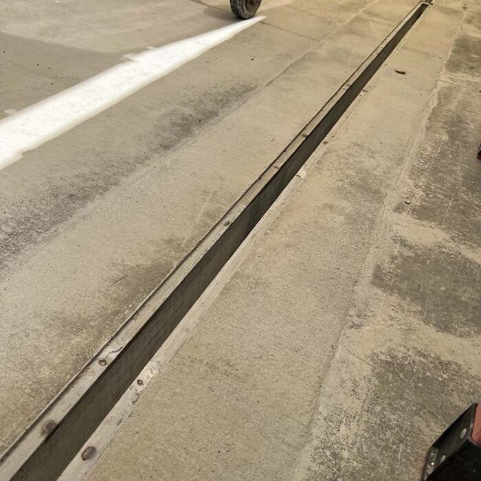 Trench drain after concrete pour with only stainless steel rails visible. Custom Stainless Steel Trench/Channel Drain utilizing a negative hard foam forming system.