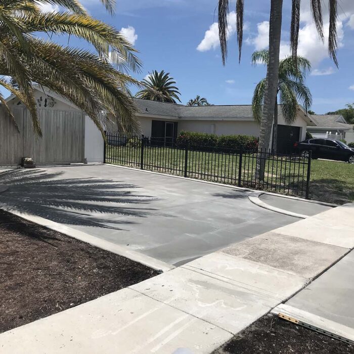 For this project, we were creating a foundation for a paver overlay. First, a reinforced concrete curb was installed which gave us our form for the driveway pavers to sit in. That foundation slab was made up of 4000lb concrete not less than 5 inches in the field and 7 inches on the thickened edge. Reinforced with .29 on 6 inch steel mesh with #5 rebar on the leading edges. This slab, on its own, will last for generations. The finish for this project was an overlay of pavers that gave us a finish that will be resilient and beautiful for generations to come.